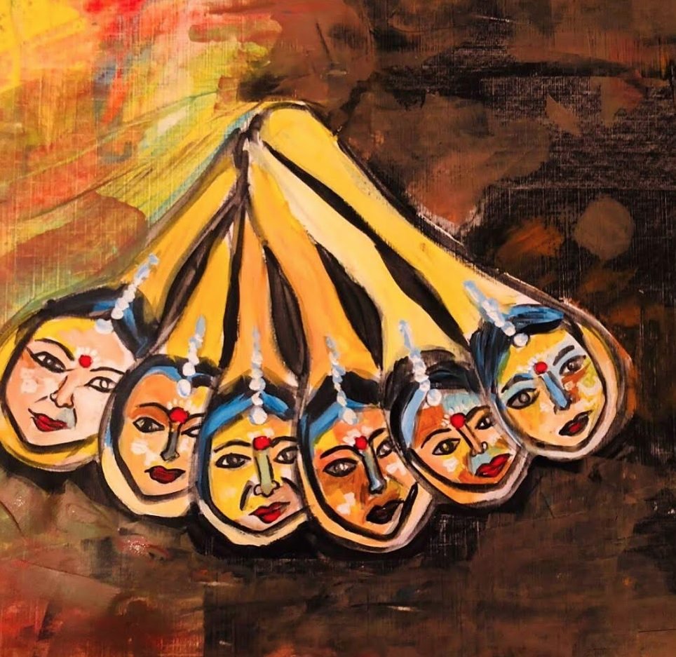 Six small painted faces fanned out on golden spokes