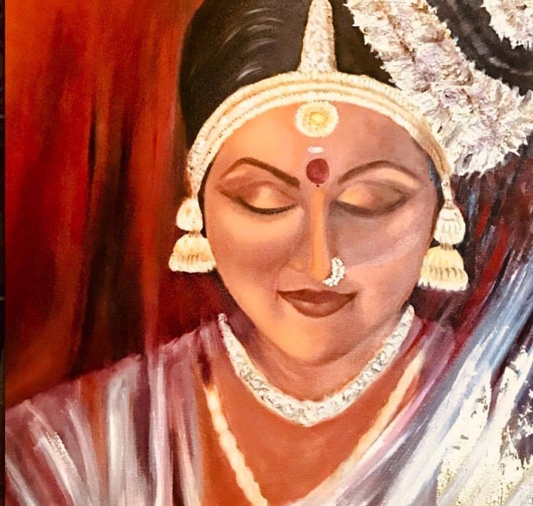 A Mohiniyattam dancer with eyes lowered, jasmine in her hair and a red bindi