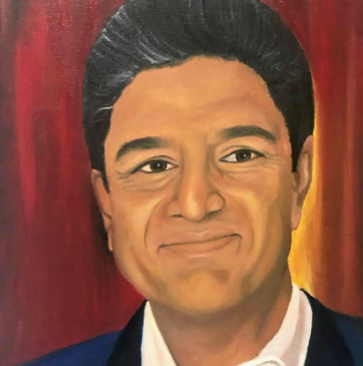 Portrait of a smiling man in a dark suit against red