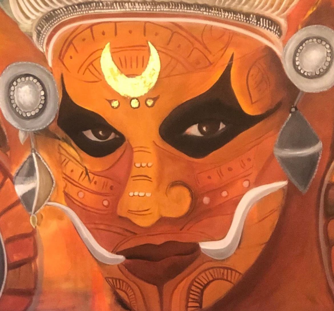 Theyyam face painted in orange and ochre with a crescent moon on the brow and silver ornaments