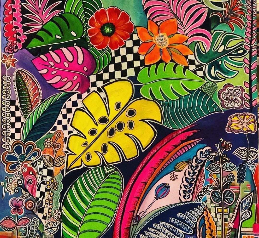 Patterned composition of tropical leaves and flowers in saturated colour